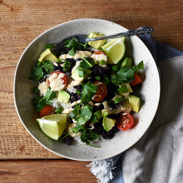 Turntable Kitchen shares a recipe for vegetarian (and vegan) Burrito Bowls with Cumin Lime Crema from A Couple Cook's new cookbook